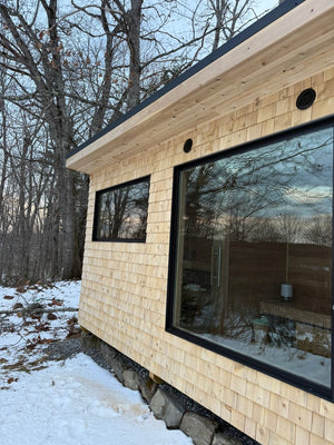 Searsmont, Maine custom sauna — cedar shingle siding and black-framed windows along the side wall