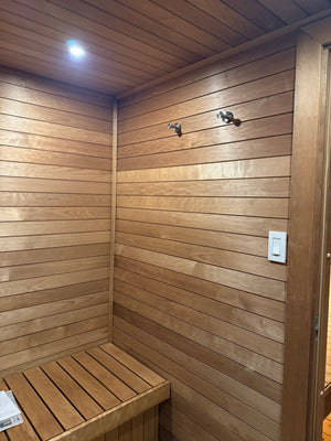 Wilton, Connecticut custom sauna — changing room, horizontal wood cladding with stainless robe hooks and a slatted bench