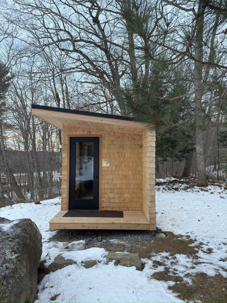 Searsmont, Maine custom sauna — porch end with glass door under the roof overhang in winter