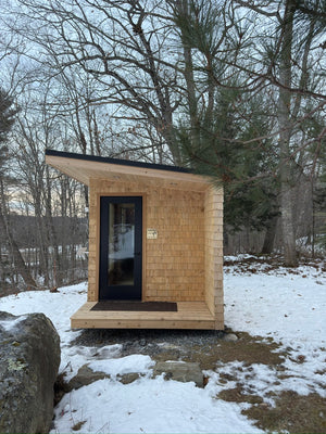 Searsmont, Maine custom sauna — porch end with glass door under the roof overhang in winter